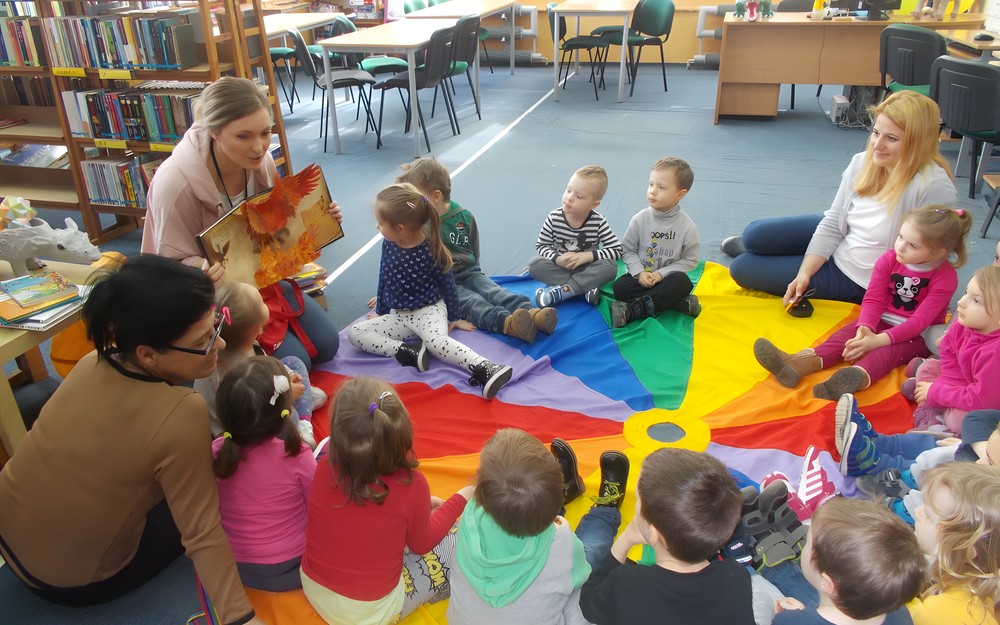 Bibliotekarka pokazuje dzieciom ksiązkę przestrzenną