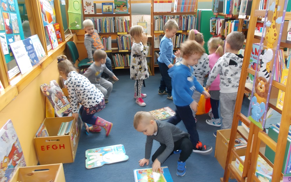 Dzieci oglądają książki w bibliotece