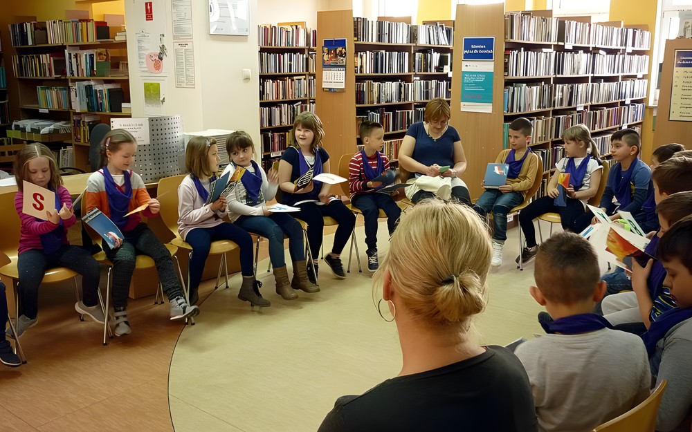 Dzieci oglądają karty z wylosowanymi literami alfabetu