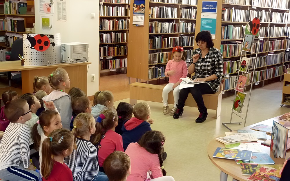 Bibliotekarka czyta książkę, Obok siedzi mała pomocnica - Biedronka Fionka (Nina)