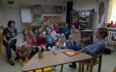 Grupa przedszkolaków słucha o przygodach Muminków