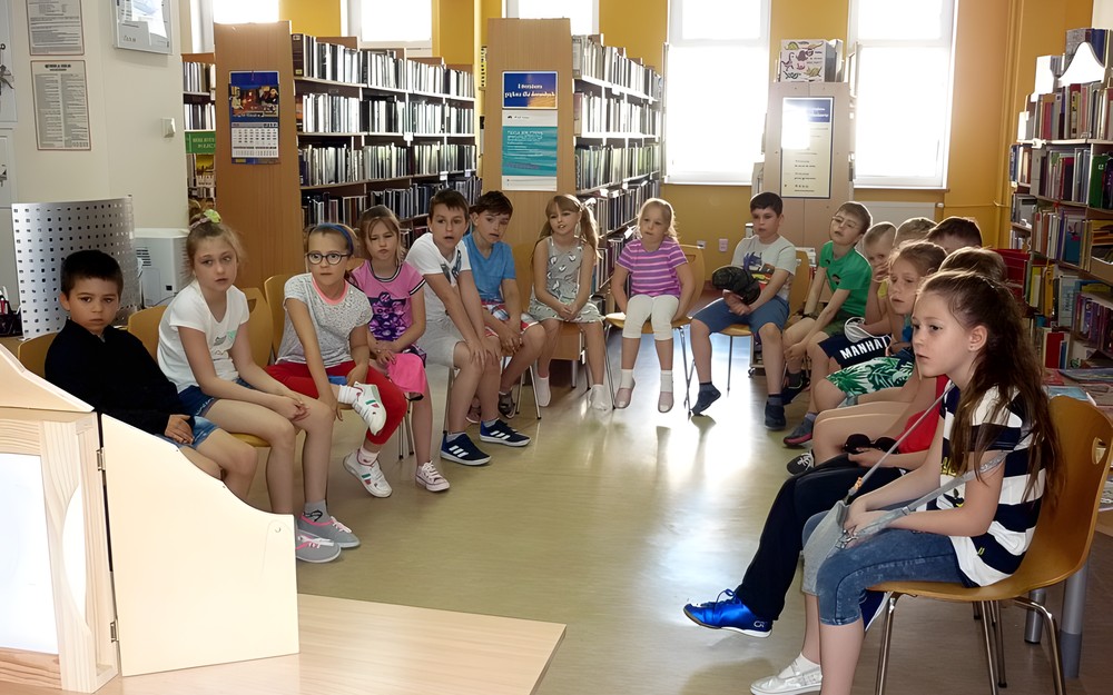 Dzieci siedzą na krzesełkach - słuchają wiersza ABECADŁO Juliana Tuwima