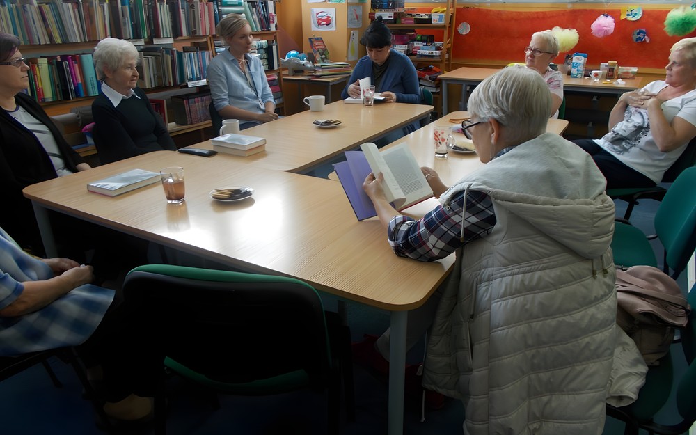 Czytelniczki siedząc przy stole dyskutują o książce