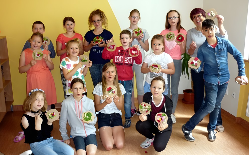 Grupa dzieci uczestniczących w warsztatach ekologicznych - w pierwszym dniu pozujemy z naszymi kwiatowymi obrazkami