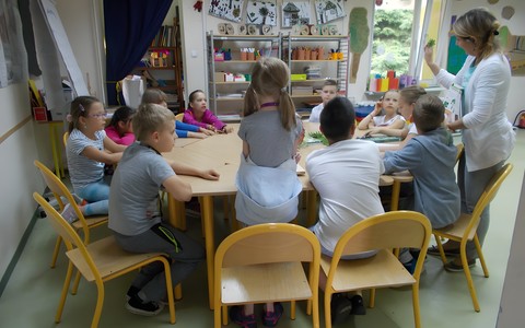 Pani bibliotekarka wyjaśnia dzieciom na czym polega robienie zielnika