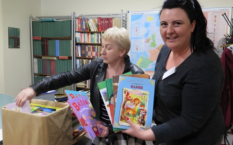 Anna Kwiatkowska przyjmuje książki od Danuty Sawickiej z biblioteki w Będzinie