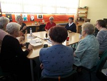 Panie siedza przy stole i dyskutują o przeczytanej książce