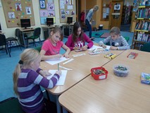 Dzieci siedzą przy stoliku i rysują