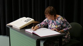 Zasłużona bibliotekarka Anna Marcinek-Drozdalska wpisuje się do Księgi Pamiątkowej Biblioteki
