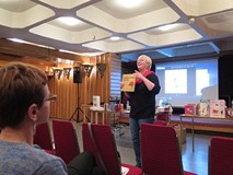 Na zdjęciu przedstawicielka grupy bibliotekarek przedstawia książeczkę dla dzieci w czasie warsztató