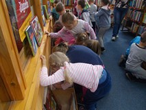 Dzieci szukają książek w kąciku malucha