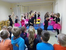 Grupa przedszkolaków tańczy na scenie