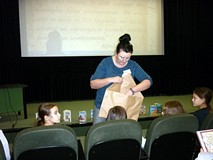 Pani Ania Kwiatkowska po prezentacji, rozdaje MOLIKOM zestawy do rozwiązania quizu