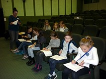 Prowadząca spotkanie czyta pytania, dzieci rozwiązują krzyżówkę