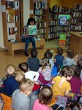 Bibliotekarka pokazuje dzieciom ilustracje do znanych bajek
