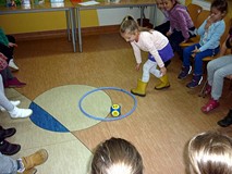 Dziewczynka rzuca kostką ; zaraz pokaże minkę widoczną na kostce
