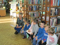 bibliotekarz głośno czyta książkę pt.