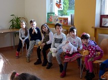 Dzieci w skupieniu słuchają czytanych misiowych historyjek