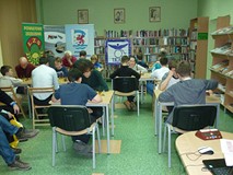 Uczestnicy w pełnym skupieniu rozgrywają partię szachów, w tle banery współorganizatorów: Koszalińsk