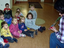 Bibliotekarka pokazuje dzieciom ilustracje do znanych baśni