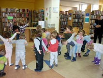 Pani Wiola pokazuje dzieciom skok narciarski, maluchy dzielnie ją naśladują