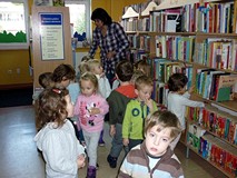 Dzieci oglądają miejsce w bibliotece, gdzie znajdują się książeczki dla 3-latków