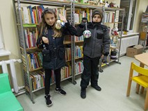 Dwoje dzieci prezentują swoje swoje świąteczne bombki