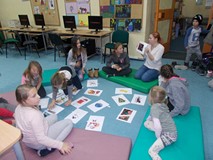 Bibliotekarka pokazuje dzieciom ilustracje, dzieci poznają słownictwo świąteczne po angielsku