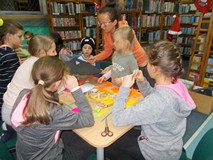 Dzieci wykonują wiszące ozdoby na choinkę