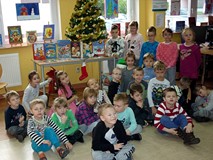 Dzieci - na tle bibliotecznej choinki - pozują do wspólnego zdjęcia