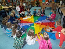 Bibliotekarka pokazuje dzieciom ilustracje zwiazane ze świętami