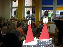 Spotkanie przebiega w świątecznej dekoracji. Czytelnię biblioteki dekorują choinka, świąteczne książ