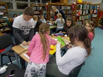 Dzieci przy stołach tworza ilustracje