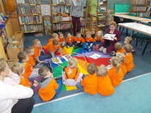 Dzieci siedzą na chuście, a jeden chłopiec wyjmuje ze środka obrazek niepasujący do świąt