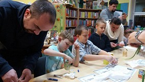 Dzieci wraz z rodzicami przy pracy plastycznej.
