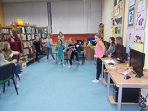 Dwie dziewczynki biegną w stronę ilustracji wypowiedzianej w języku angielskim przez bibliotekarkę, 