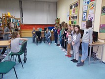 Dwie dziewczynki biegną w stronę ilustracji wypowiedzianej w języku angielskim przez bibliotekarkę, 