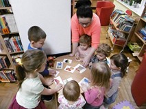 Dzieci wspólnie z bibliotekarką podczas wspólnej pracy.