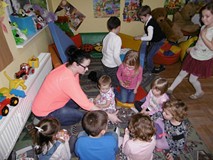 Bibliotekarka częstuje dzieci cukierkami.