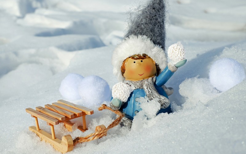 Lalka z sankami na śniegu