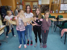 Cztery dziewczynki pozują do zdjęcia ze swoją pracą