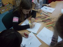 Trzy dziewczynki siedzą i rysują kredkami to, co mogło wysypać się z puszki Pandory