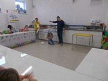 Dziewczynka trzyma w ręku parasol, a pan leje wodę