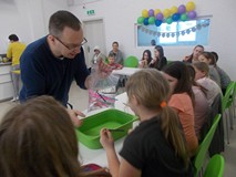 Dziewczynka wbija kolejną kredkę w worek napełniony wodą