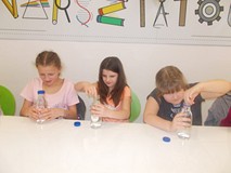 Trzy dziewczynki obserwują, czy eksperyment się powiedzie