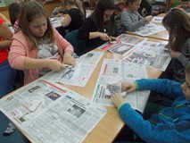 Dzieci siedzą przy stole i rzeźbią rybę w mydle