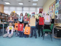 Dzieci pozują do zdjęcia ze swoimi pracami