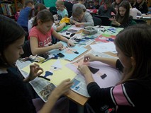 Dzieci siedzą przy stole i wykonują cyklopa