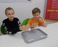 Dwóch chłopców wykonuje doświadczenia z wodą