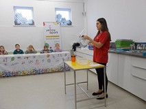 Dzieci patrzą na Panią, która wykonuje doświadczenia